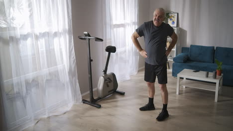 athletic-middle-aged-man-is-doing-physical-exercises-in-living-room-in-his-apartment-healthy-lifestyle-of-middle-aged-people